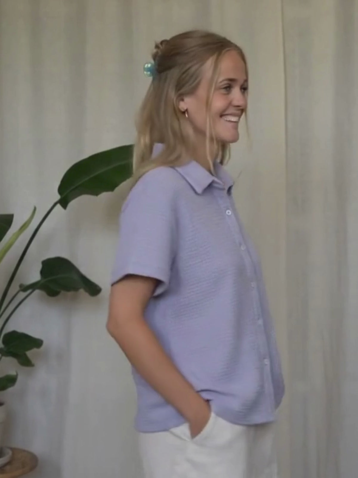 Greta trägt die lavendelfarbene Kurzarmbluse von FUXBAU aus 100% Biobaumwolle, GOTS zertifziert und nachhaltig und fertig in Portugal gefertigt.

