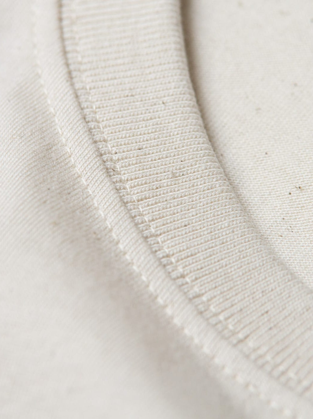 Detailansicht vom Kragen eines nachhaltiges FUXBAU Fair Fashion schweren Basic T-Shirt in Natur aus Biobaumwolle.