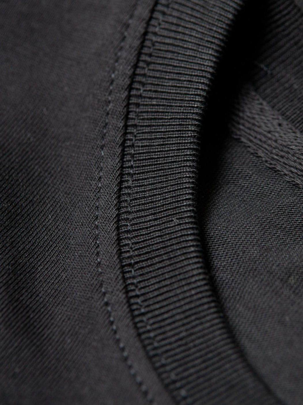 Detailansicht vom Kragen eines nachhaltiges FUXBAU Fair Fashion schweren Basic T-Shirt in schwarz aus Biobaumwolle.