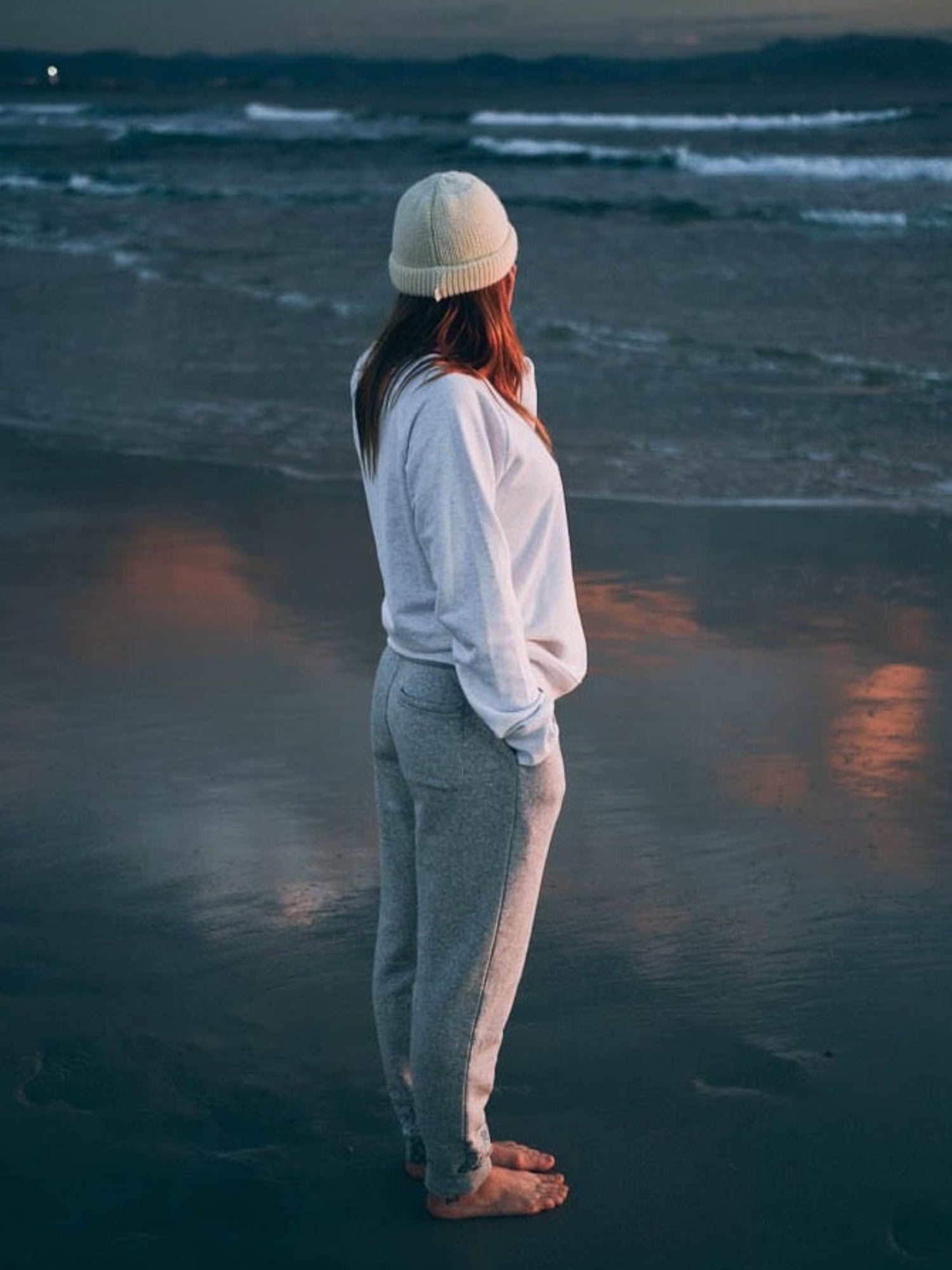 Nachhaltige far fashion Jogginghose von FUXBAU aus grau meliertem Stoff aus Biobaumwolle. Getragen am Strand in Spanien.