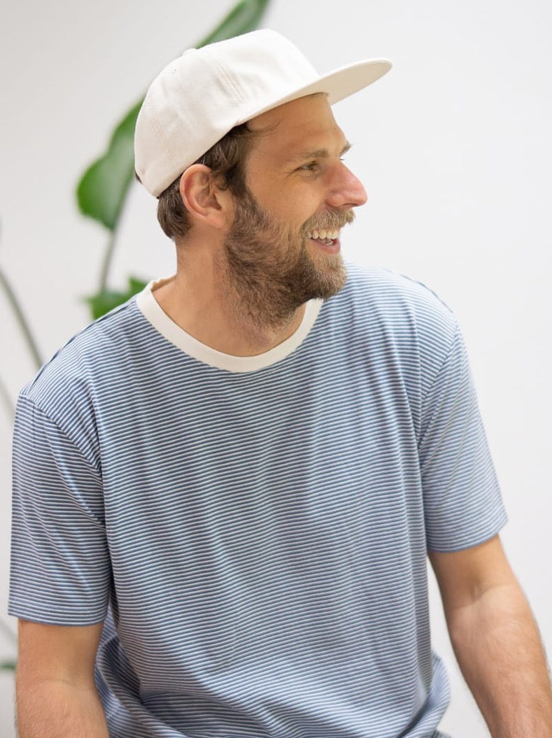 Philipp trägt unser Fair Fashion Männer Streifenshirt in creme blau aus 100% GOTS zertifizierter Biobaumwolle