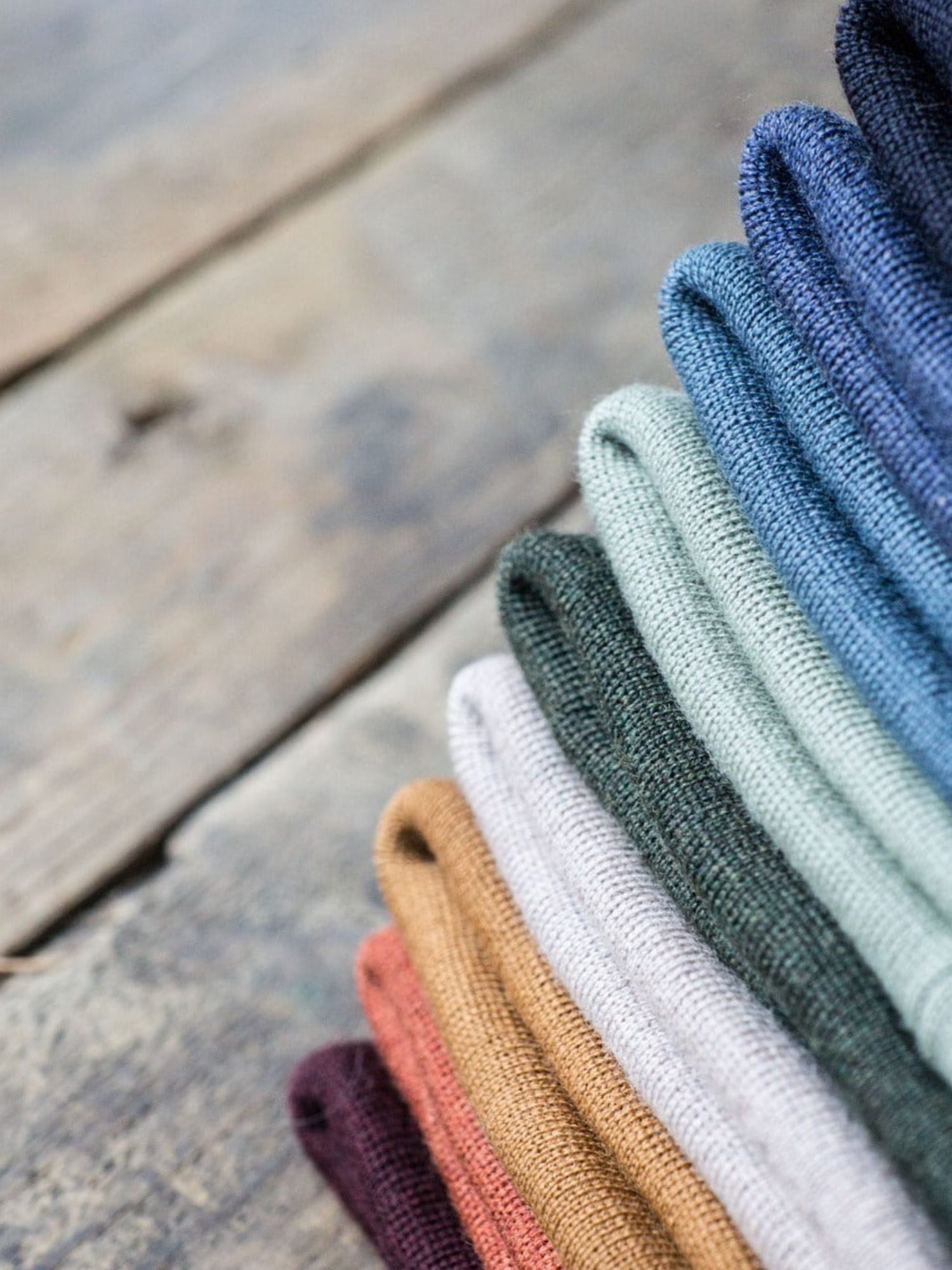 Stapel an nachhaltigen Fair Fashion Merino Kork Mützen für Kinder von FUXBAU aus 100% nachhaltiger Merino Schurwolle gefertigt in Deutschland mit Kork-Patch.